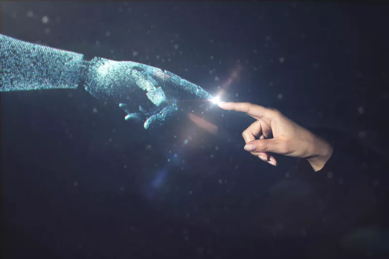 Human hand touching AI robot hand