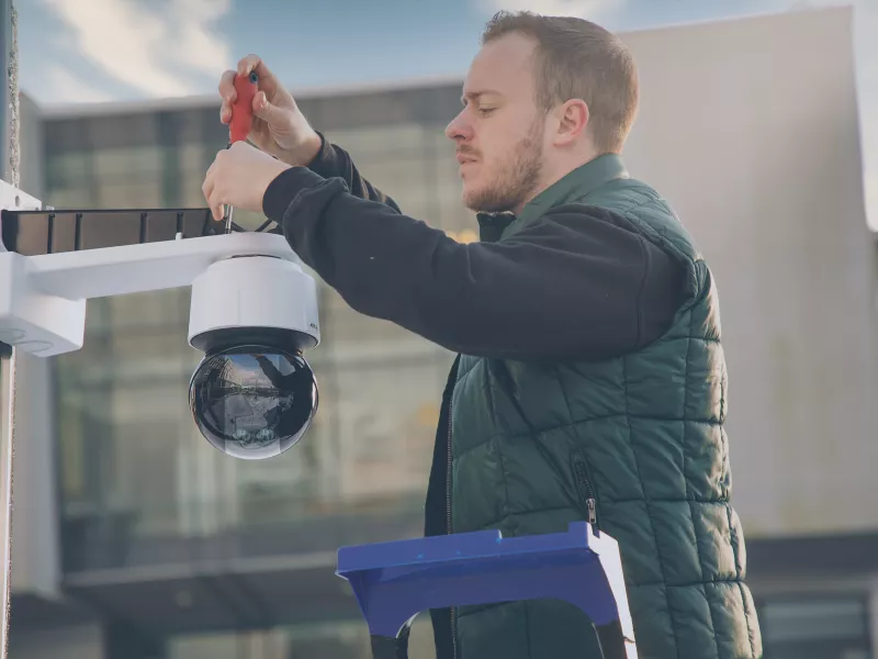A man mounting a camera on the roof