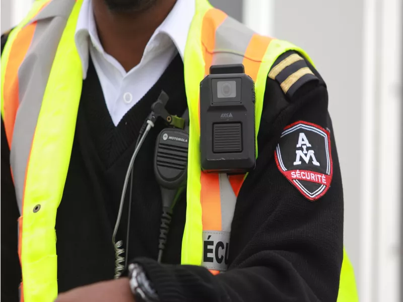 Body worn camera attached to safety vest of AIM security guard